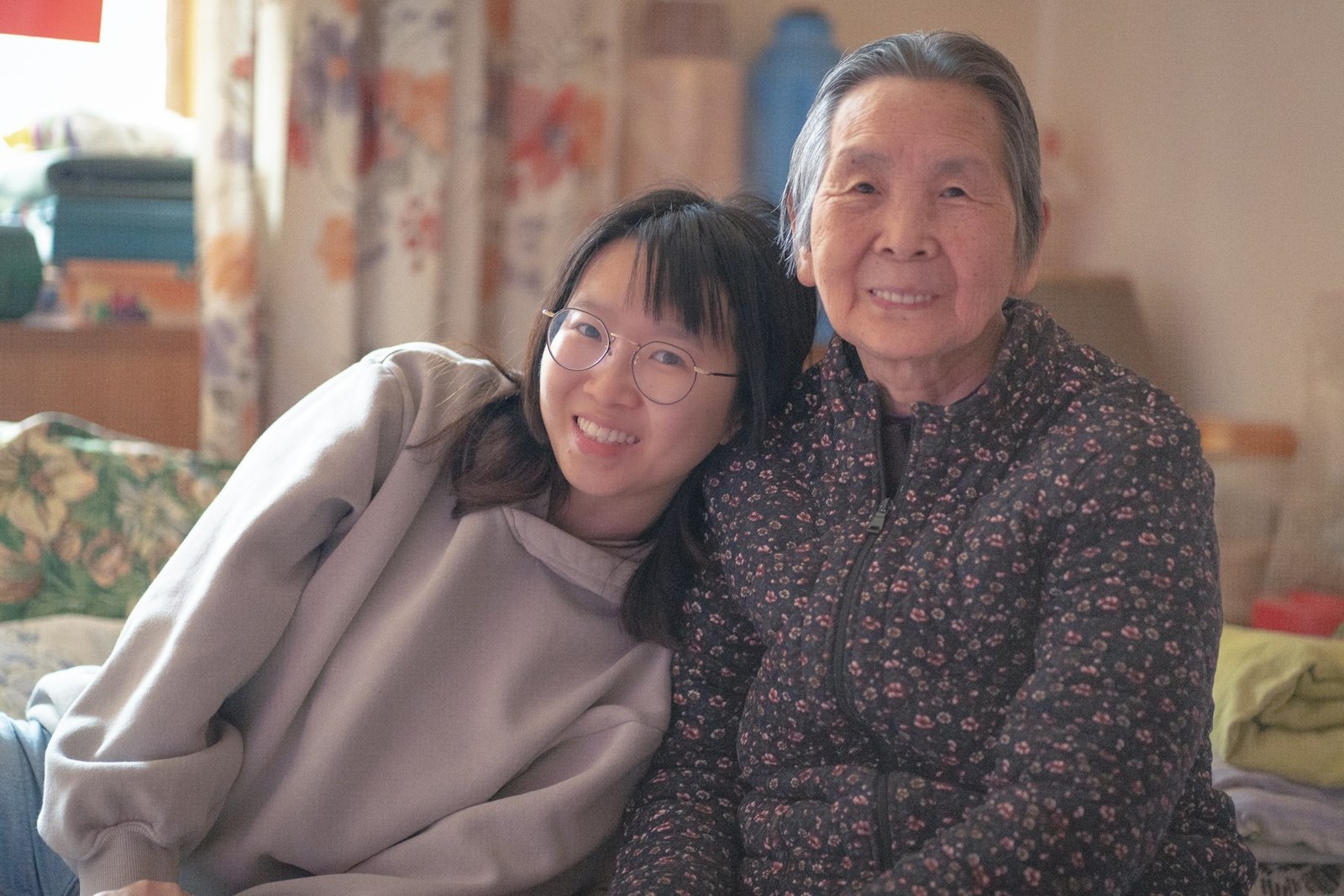 An adult daughter sitting close to her elderly mother during a conversation at home
