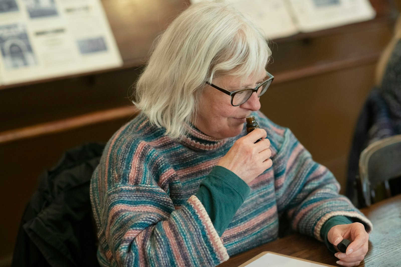 An older woman with glasses reading paperwork thoughtfully