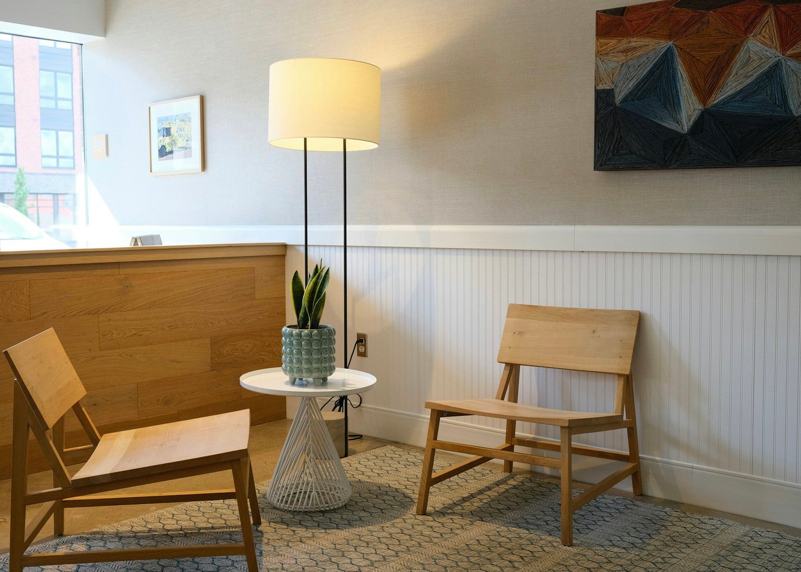 A bright, calm seating area with armchairs and a floor lamp in a senior living community