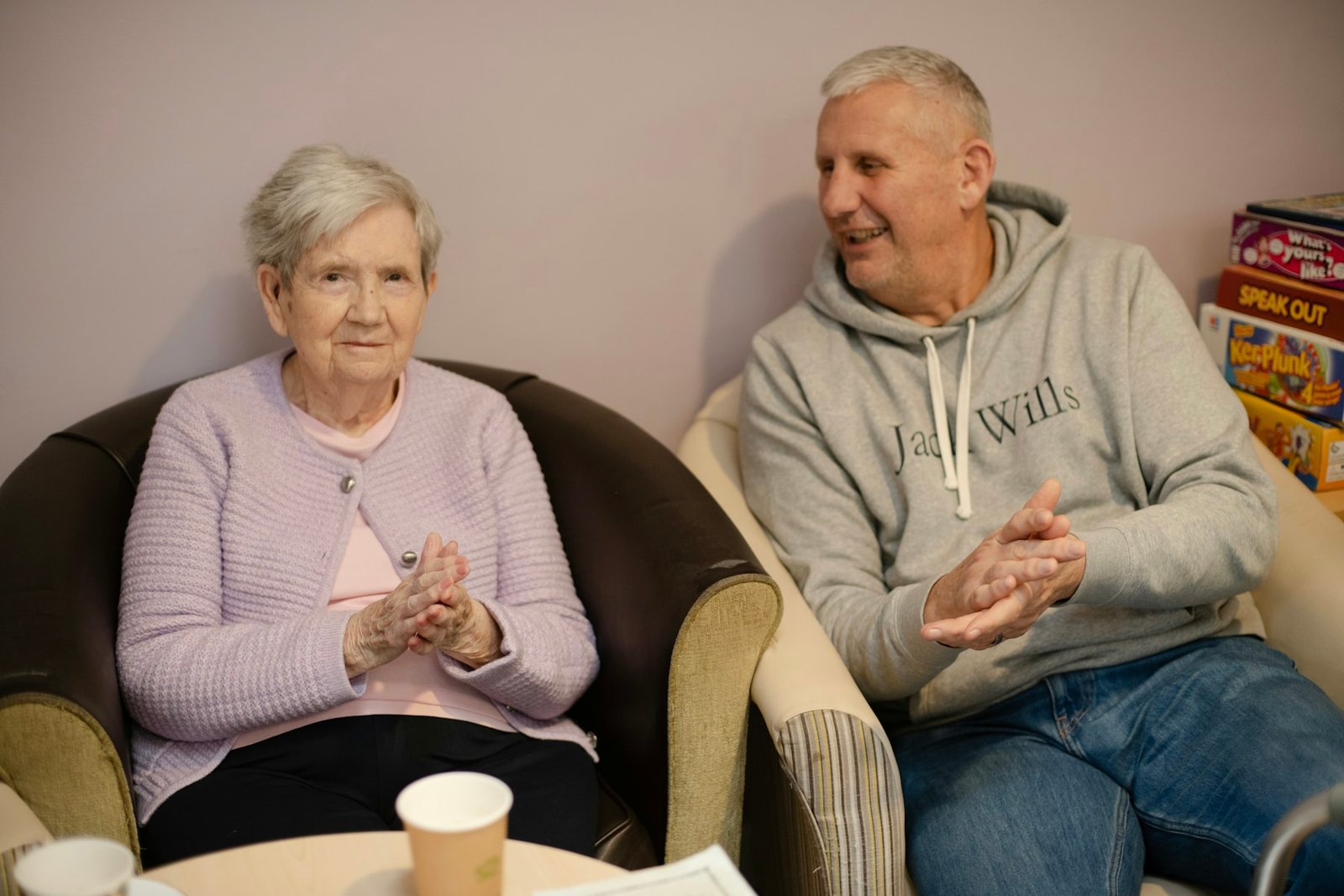 An older woman and her adult son talking together in a bright living room