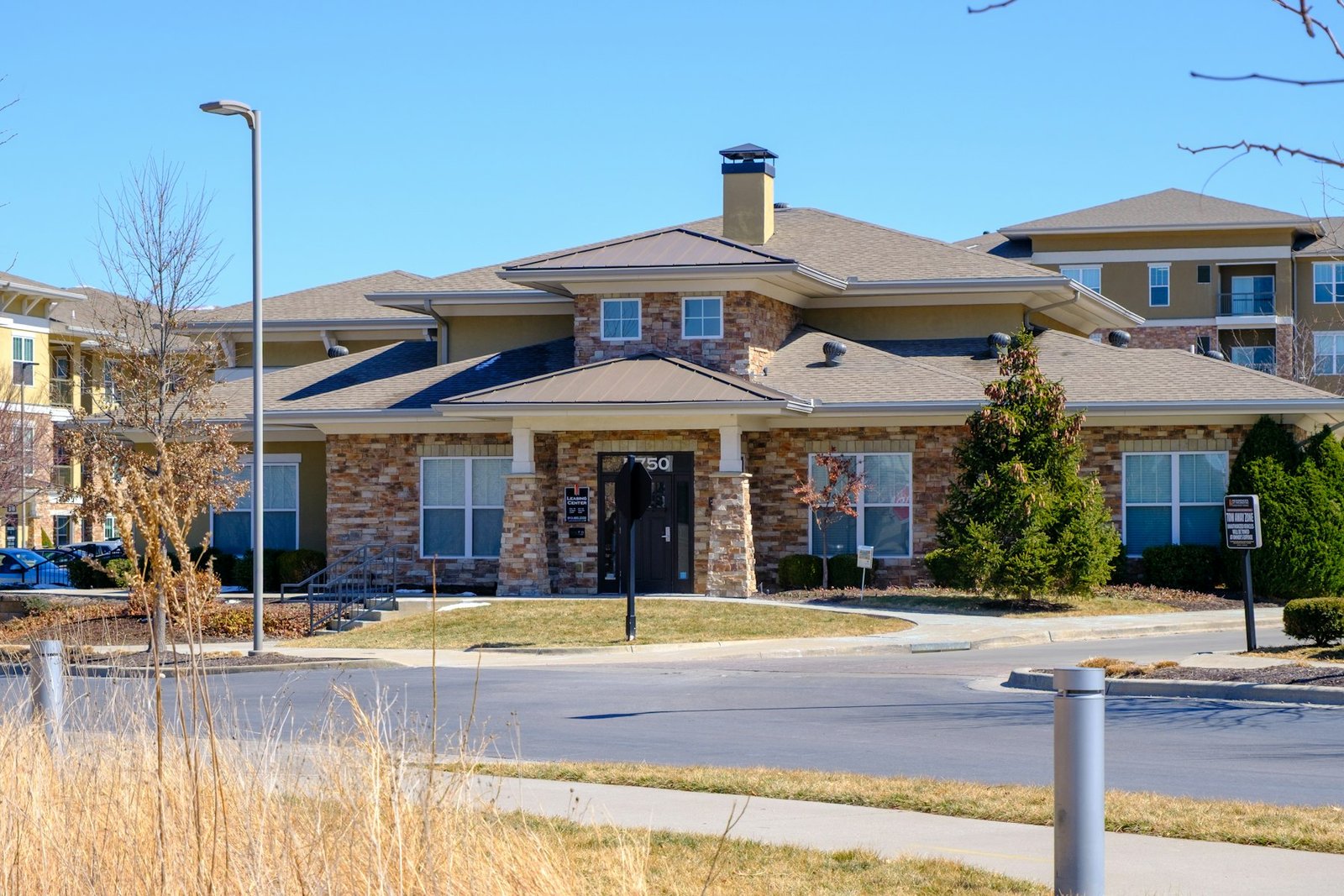 Exterior of a single-story senior living community with a landscaped entrance